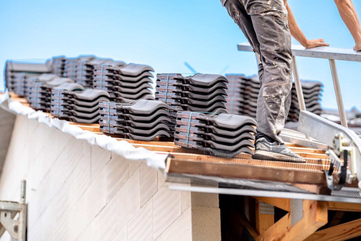 Arbeiter verlegt neue Dachziegel Arbeiter verlegt neue Dachziegel